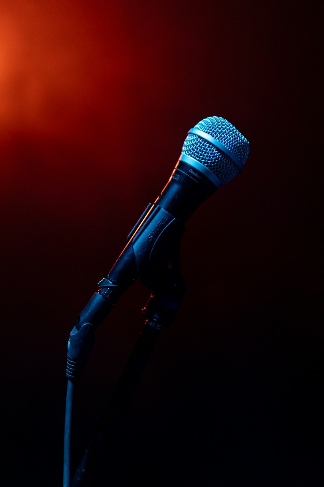 Close-up of a professional microphone in a dim recording studio