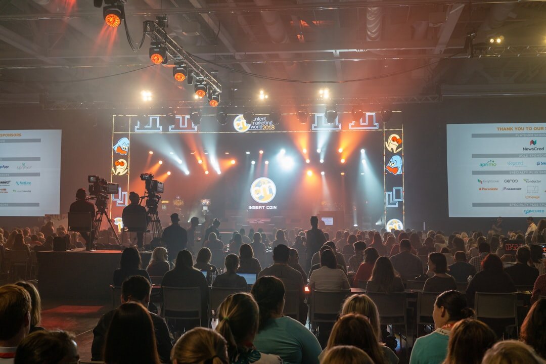 Panel discussion on stage in front of a seated audience at a conference